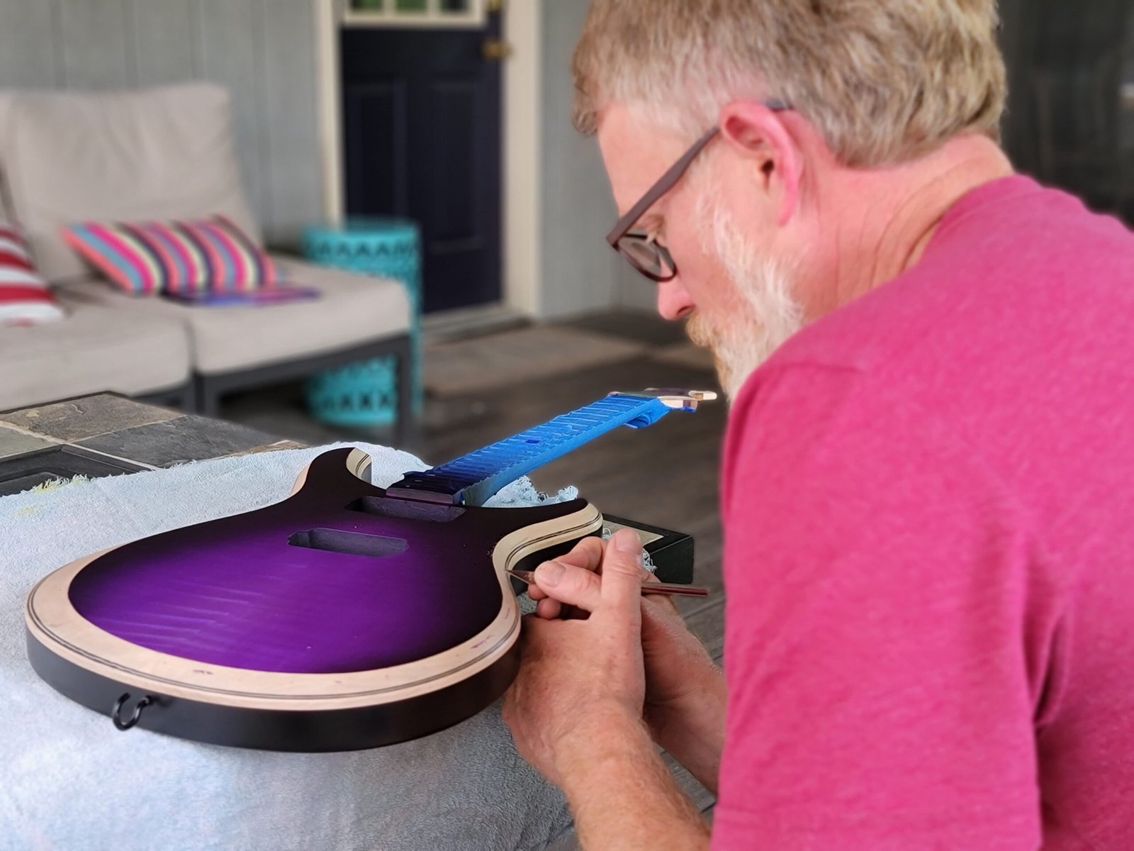 Darrick uses a scalpel to carefully remove overspray, ensuring every Ellehsem Guitars detail meets the highest quality standards.